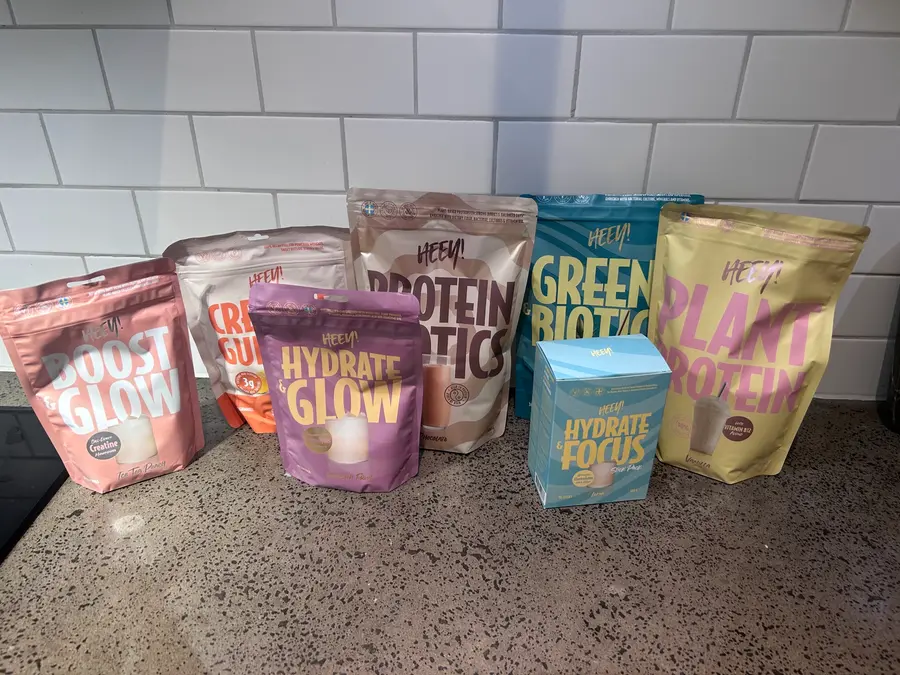 Sju Heey-produkter uppställda på en köksbänk, bland annat Creatine Gummies och Plant Protein